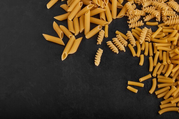 Pasta varieties in the grocery stock on black background. 