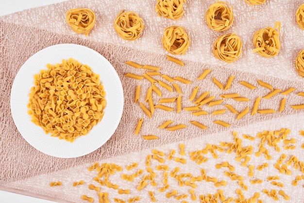 Pasta varieties on pink tablecloth.