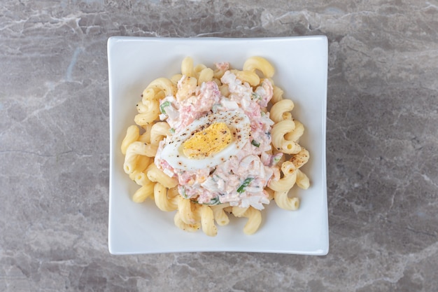 Free photo pasta with boiled eggs in white bowl.