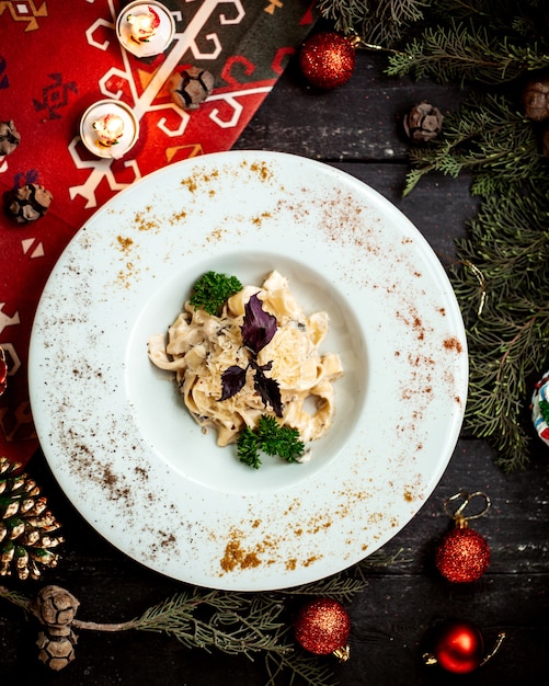 Pasta with cheese and mushrooms topped with basil