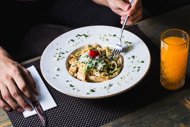 Foto gratuita pasta con pollo pomodori verdi e formaggio grattugiato servito con succo