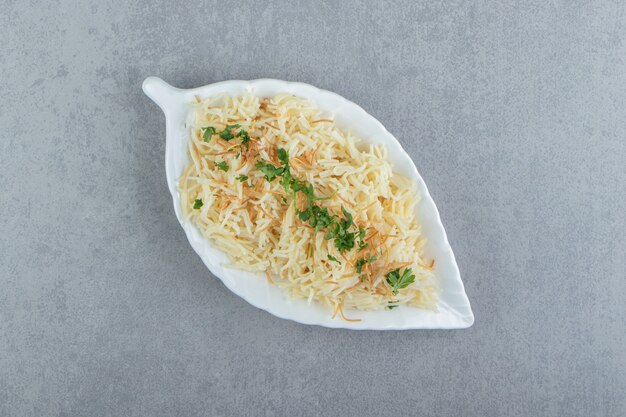 葉の形をしたプレートにパセリのみじん切りのパスタ。