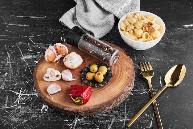 Pasta with ingredients on black background. 