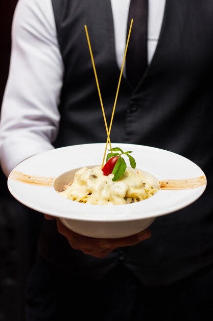 Pasta with melted cheese and cherry tomato on top