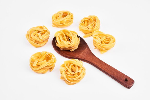 Pasta in a wooden spoon on white