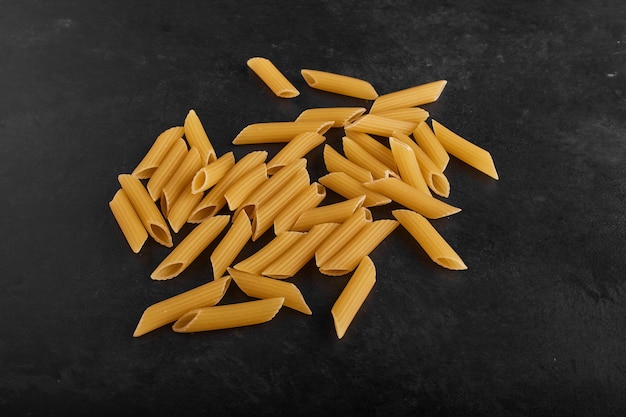 Pastas isolated on black surface in the center. 