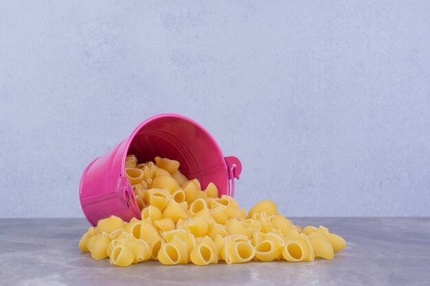 Pastas out of a pink metallic bucket. 