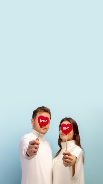 Free photo pastel. beautiful couple in love on blue studio background. saint valentine's day, love, relationship and human emotions concept. copyspace. young man and woman look happy together.