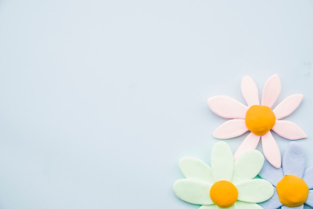 Pastel clay flowers on gray background