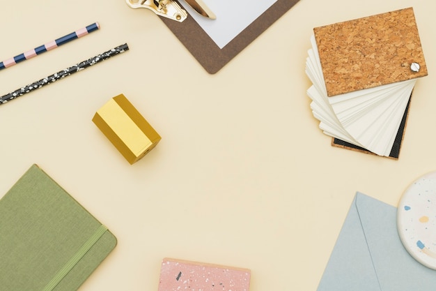 Free photo pastel stationery frame on a beige table