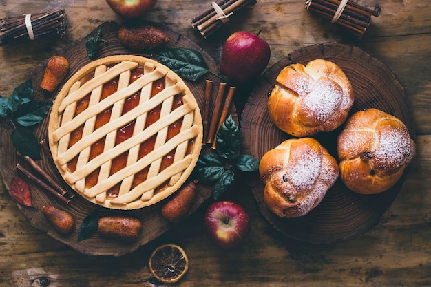 Pastry and apples on wooden background