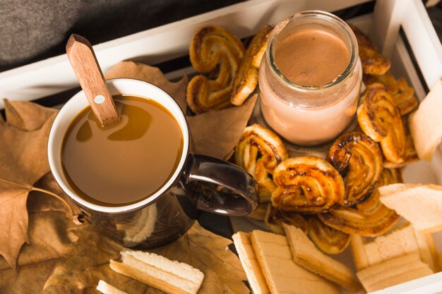 Pastry and beverages amidst leaves