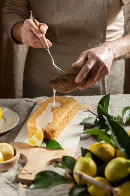 무료 사진 레몬 케이크에 토핑을 추가하는 생과자 요리사
