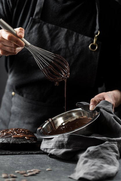 Foto gratuita pasticcere che prepara la torta al cioccolato