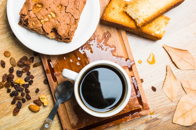 レーズンと葉の近くのペストリーとコーヒー