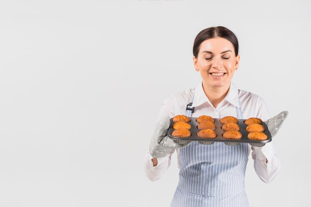 Pastry cook female smelling muffins 