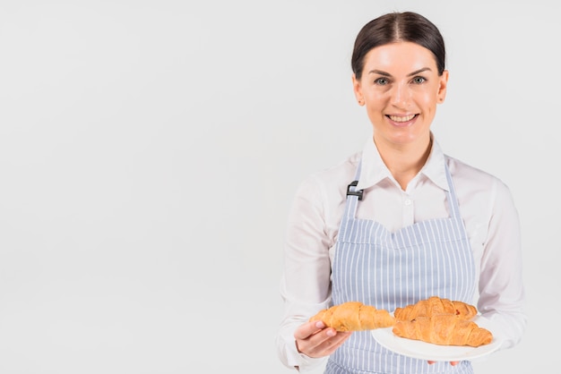 Pastry cook woman offering croissant 