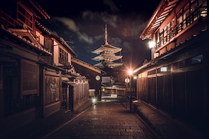 Pathway in the middle of buildings under a dark sky in japan