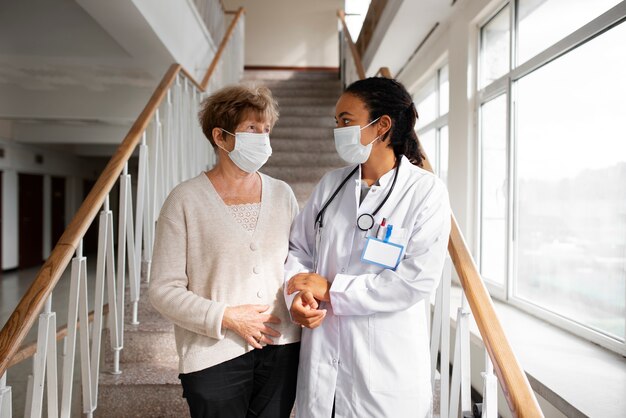 Patient and doctor walking together medium shot