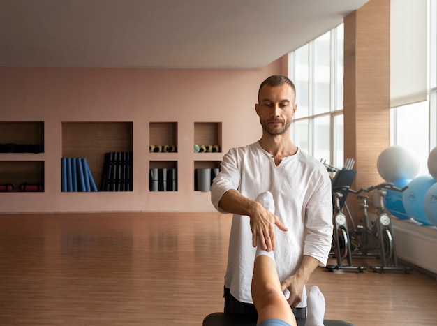 Patient doing physical rehabilitation helped by therapists