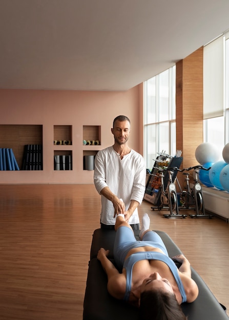 Free photo patient doing physical rehabilitation helped by therapists