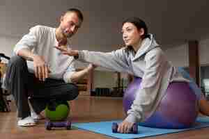 Free photo patient doing physical rehabilitation helped by therapists