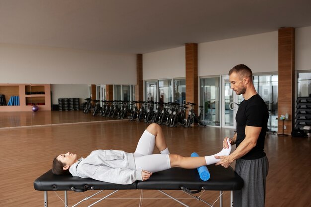 Patient doing physical rehabilitation helped by therapists