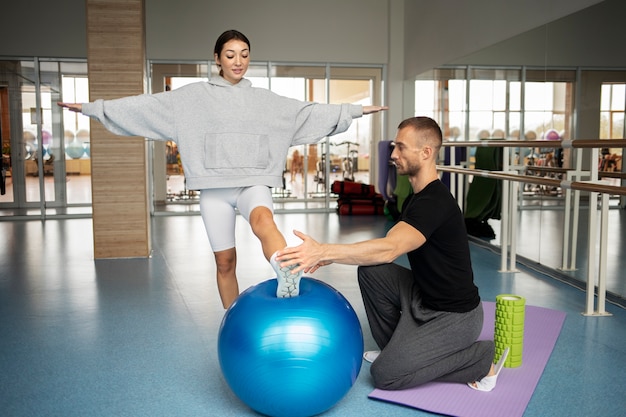 Free photo patient doing physical rehabilitation helped by therapists