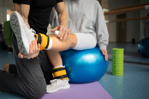 Patient doing physical rehabilitation helped by therapists