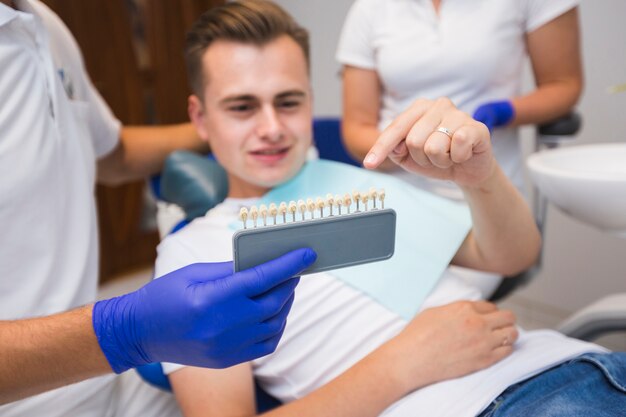 Пациент, указывая на зубы с стоматологом