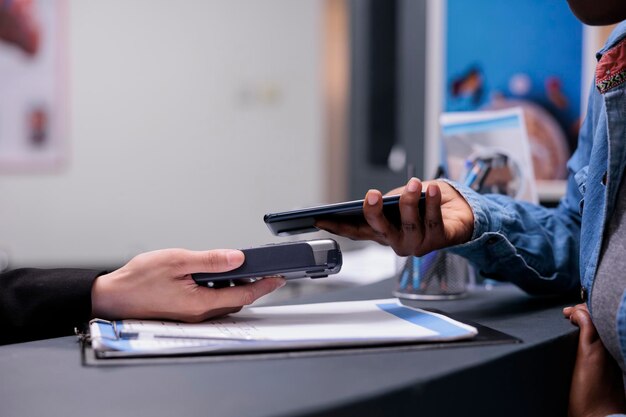 Patient using credit card to pay checkup visit with specialist, paying for consultation and treatment at facility reception desk. Making payment after having examination appointment. Close up.