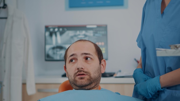 Бесплатное фото Пациент с проблемами кариеса получает консультацию от бригады стоматологов. стоматологи осматривают протезы с зубными инструментами, осматривают зубы для процедуры ухода за полостью рта.
