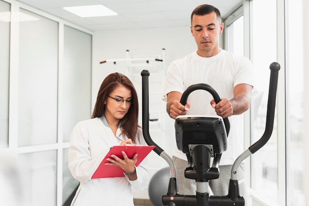 Patient working out while doctor writing