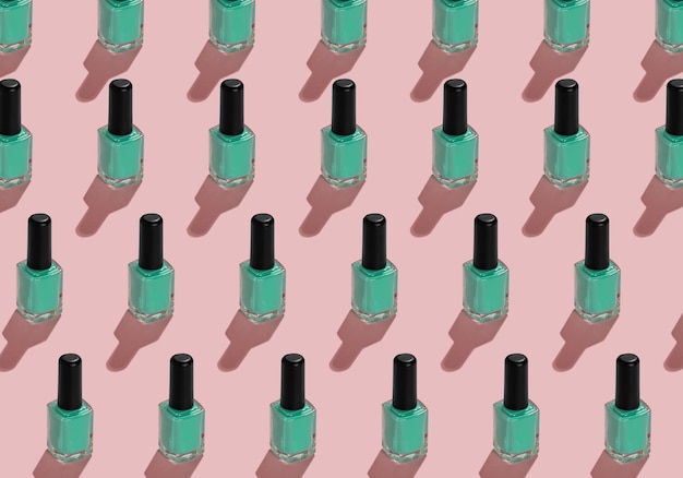 Узор из бутылок с эмалью для ногтей с зеленой эмалью на розовом фоне