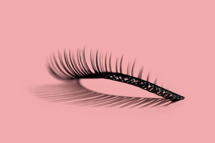Free Photo a pattern of separate false lashes on pink background with hard light makes shadow