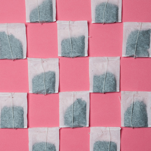 Pattern of white tea bag on pink background