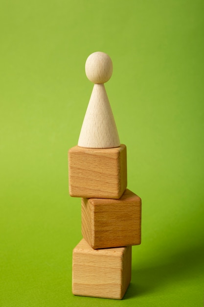 Pawn on wooden cubes with green background