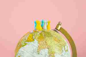 Free photo pawns on world globe with pink background