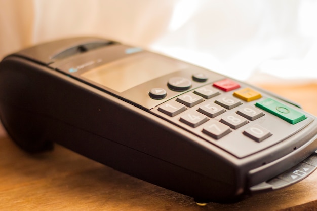 Payment card in a bank terminal. The concept of of electronic payment.  counter with terminal in supermarket. wireless pos terminal with card waiting for pin