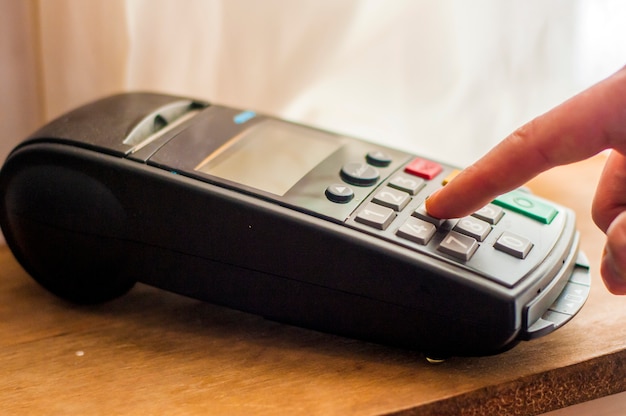 Payment card in a bank terminal. The concept of of electronic payment. hand pin code on pin pad of card machine or pos terminal good photo. businessman holding pos terminal.