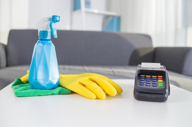 Payment terminal besides spray bottle and rubber gloves