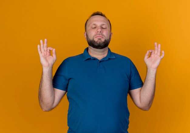 Peaceful adult slavic man meditating with closed eyes 