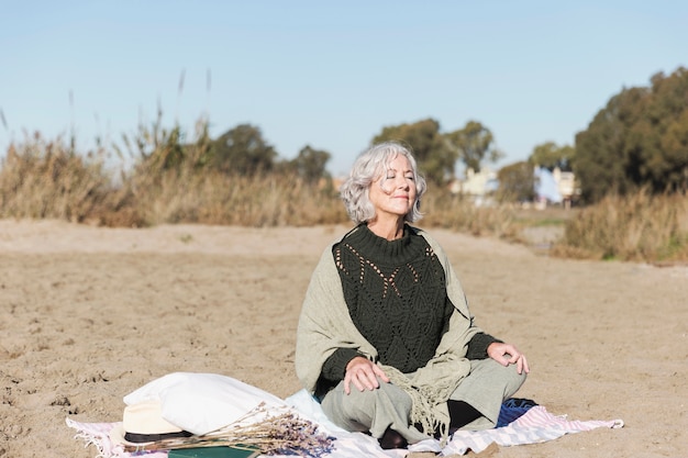 Мирная старшая женщина размышляя outdoors