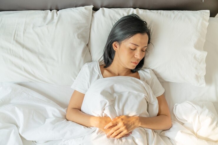 무료 Photo 평화로운 고요한 젊은 아가씨는 침대에 잠옷을 입습니다. 평면도