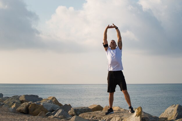 Peaceful young runner stretching after training