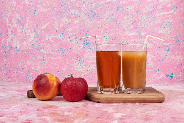 Free photo peach and apples with cups of juice.