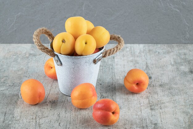 Peach and apricots in a silver container