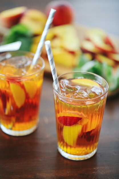 Peach juice in cups with fruit slices inside