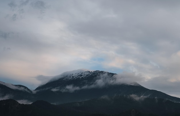 눈 속의 산봉우리는 구름의 자연적 배경에 싸여 지중해 연안의 겨울 풍경에 대한 생각
