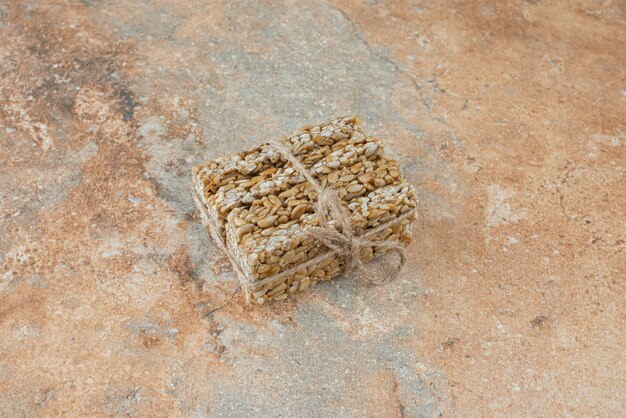 Peanut brittles in rope on marble background